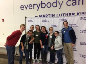 A group smiles while volunteering at a warehouse.