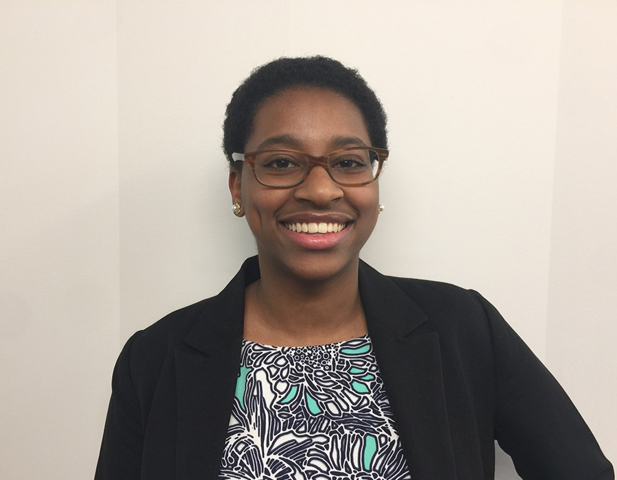 Chemistry Major Eleane Lema poses in front of a wall.