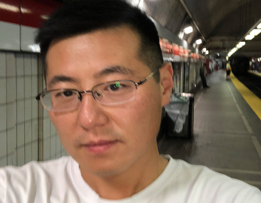 Postdoctoral researcher Wen Zhou stands on the subway platform.