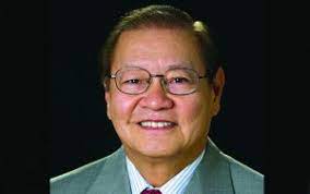 A headshot of a smiling man.