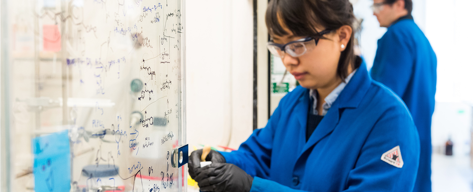 Two graduate students conduct research in a lab.