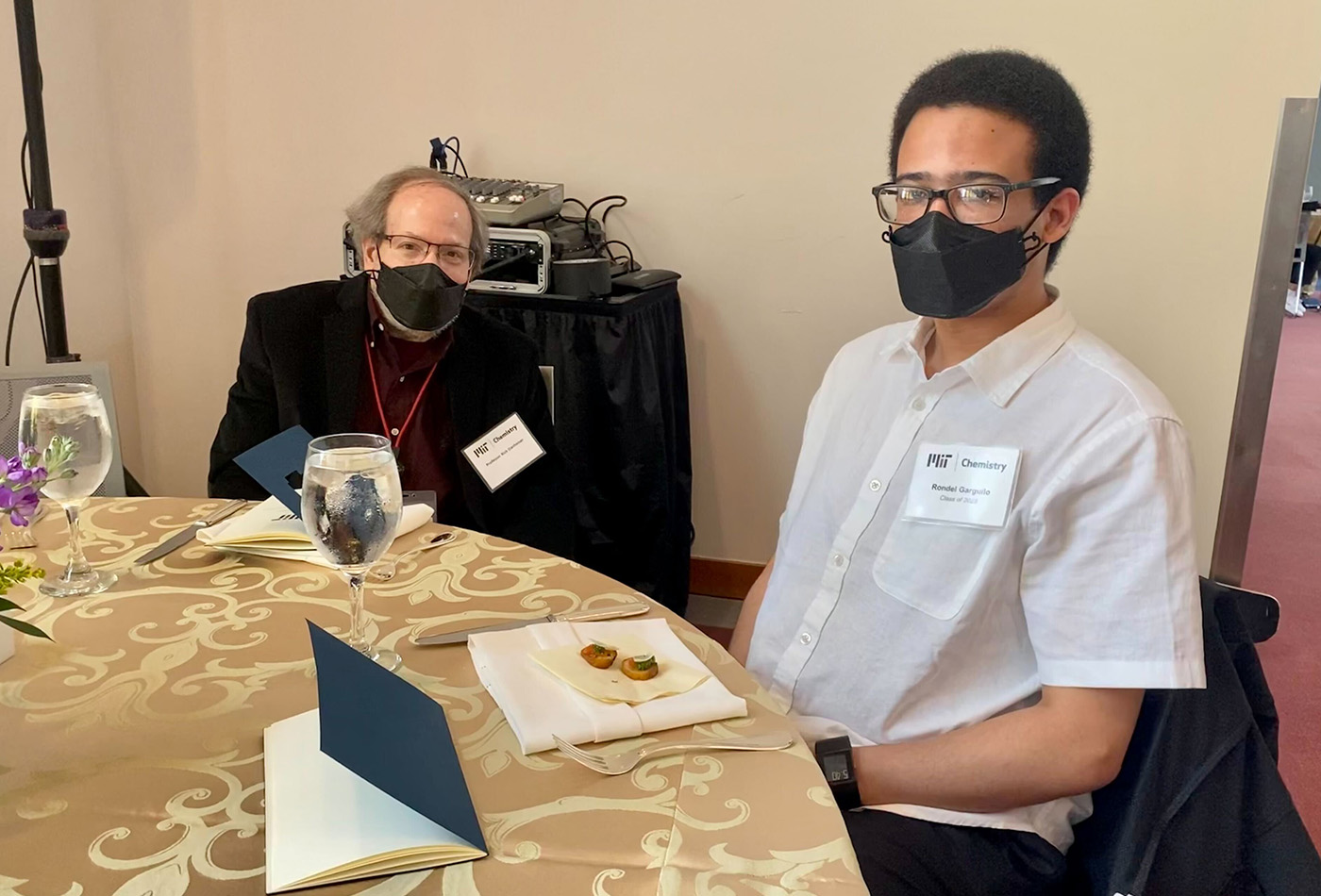 Two men sit at a table.