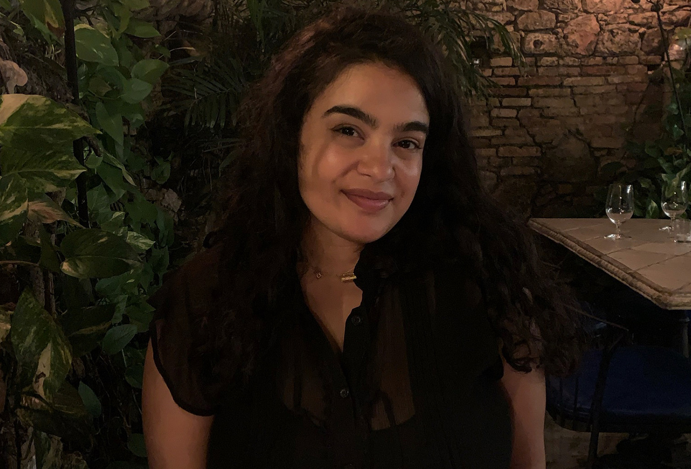 A woman in a restaurant smiles.