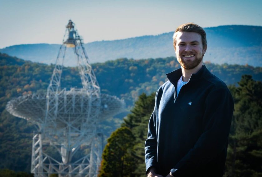 Zachary Fried smiles in front of a mountain vista.