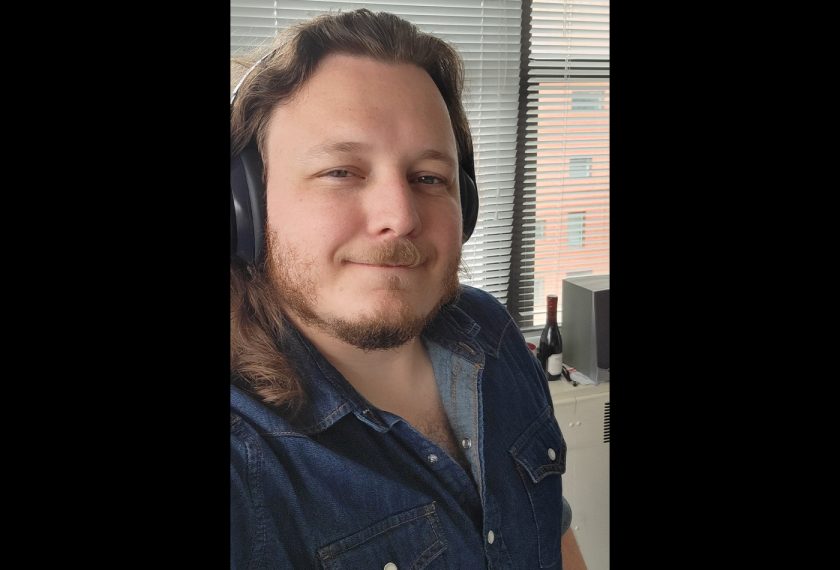 Nicolas Matthey smiles wearing headphones.