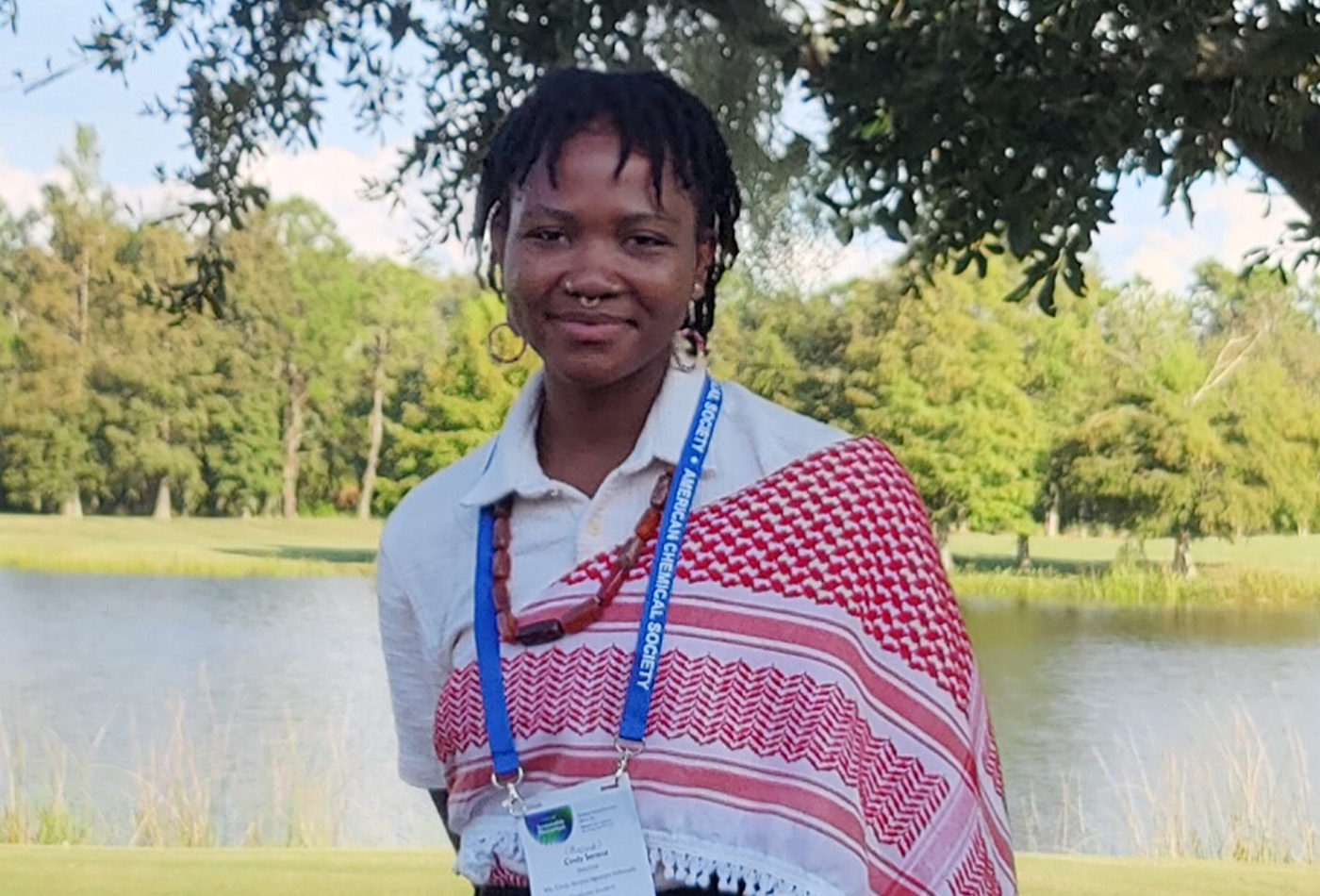 Cindy Serena Ngompe Massado smiles in front of a pond.